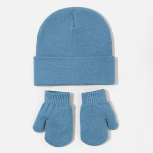 Detailed macro view of the light blue knitted texture on baby beanie and matching mitten set
