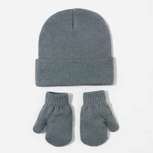 Detailed view of soft grey knitted baby beanie hat and matching mittens set for winter