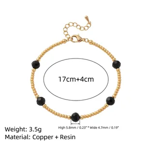 Pulsera vintage de cuentas doradas con detalles de resina negra y una cadena.