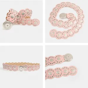 Gedetailleerde weergave van roze bohemian riem met bewerkte zilveren metalen medaillons.