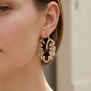 Detailansicht eines 18K vergoldeten Ohrrings mit Blattdesign und funkelnden Steinen.