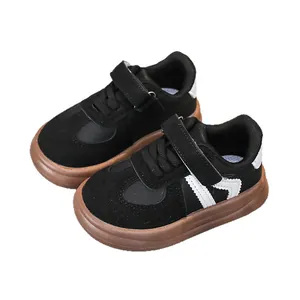 Black children's anti-slip sneakers with soft brown soles and white strap accents