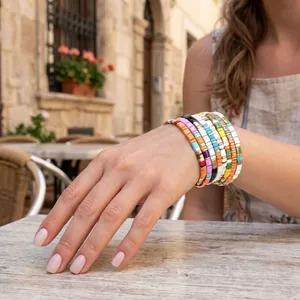 Braccialetti elastici in perle Tila macaron colorati indossati al polso di un modello