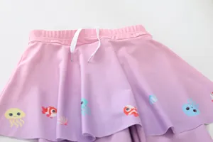 Detailansicht des rosa-violetten Mädchen-Baderocks mit niedlichen Meeresmotiven