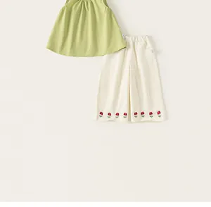 Completo estivo da bambina in due pezzi con top verde a pieghe e pantaloni a fiori