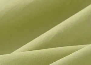 Primo piano della consistenza del tessuto plissettato verde chiaro per abiti da bambina