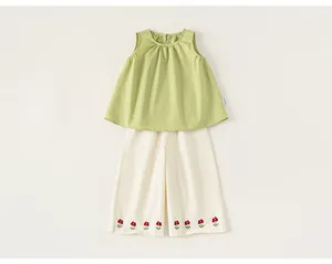 Vista dettagliata del set estivo da bambina con top verde e pantaloni ricamati