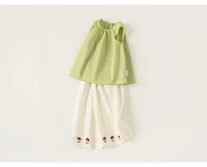Dettaglio completo estivo da bambina con top senza maniche verde e pantaloni ricamati