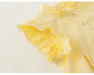 Dettaglio di un top estivo giallo da bambina con maniche a volant e trama plissettata