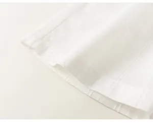 Macro dettaglio della trama del tessuto plissettato bianco per abbigliamento estivo bimba