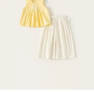 Vista dettagliata del set estivo da bambina con top giallo e pantaloni bianchi