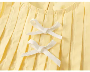 Vista macro dettagliata del tessuto plissettato giallo con eleganti fiocchi bianchi