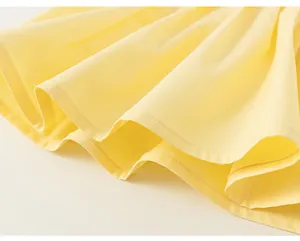 Dettaglio ravvicinato delle cuciture su tessuto plissettato giallo per top estivo bimba