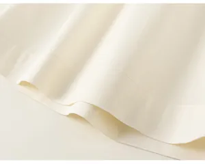 Dettaglio macro dell'orlo in tessuto bianco con cuciture pulite su completo bimba
