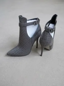 Detailansicht der grauen Stiefeletten mit Krokoprägung, Stilettoabsatz und Ausschnitten.