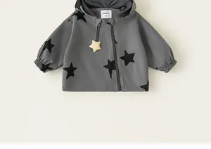 Close-up of kids hooded windbreaker with black star patterns and star zipper pull