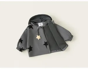 Close-up of a grey girls' hooded windbreaker jacket featuring bold black star patterns