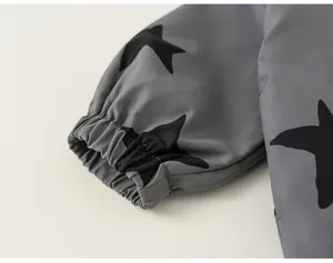 Detailed close-up of elastic cuff on gray star print windbreaker jacket for kids