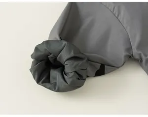 Detail shot of elasticated cuff on grey girls outdoor windbreaker with polka dot pattern