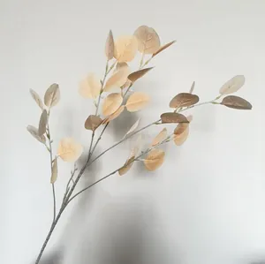 Close-up of realistic artificial beige eucalyptus leaf branch for wedding decor