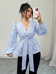 Elegant light blue V-neck blouse with puff sleeves and tie-waist detail in mirror selfie.