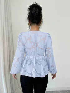 Back view of light blue semi-transparent long-sleeve blouse with floral jacquard pattern