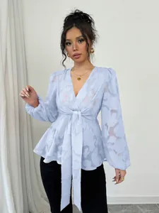 Detailed view of a light blue semi-transparent V-neck blouse with tie-front design.