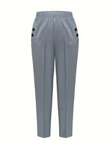Detail view of blue high-waisted tapered trousers with elastic waistband and buttons