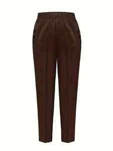 Detail of high waist brown trousers featuring elastic waistband and button pockets
