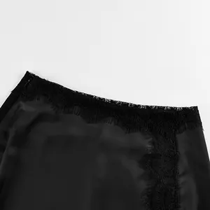 Close-up detail of a black satin skirt featuring delicate floral lace trim and texture.