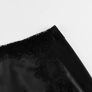 Macro detail of black satin skirt featuring delicate floral eyelash lace embroidery