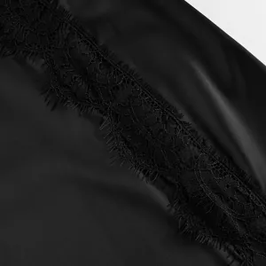 Macro detail shot of intricate black floral lace trim on elegant smooth satin fabric.