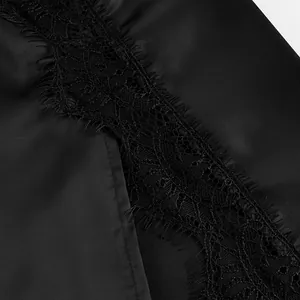 Close-up detail showing the delicate black eyelash lace trim on smooth satin fabric skirt