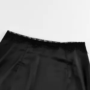 Detailed view of black satin midi skirt with elegant lace trim at the waistline.