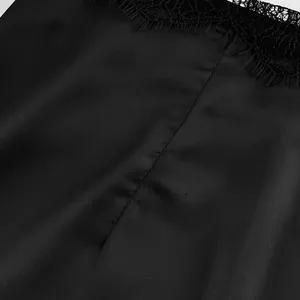 Macro close-up detail of elegant black satin skirt fabric with delicate lace trim texture
