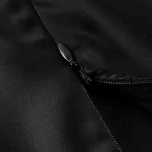 Macro detail showing the smooth hidden zipper on a black satin asymmetric midi skirt