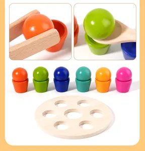 Primo piano di palline, tazze, pinze e cucchiai colorati Montessori in legno naturale