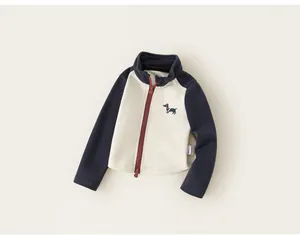 Gros plan d'un sweat-shirt zippé bleu marine et beige pour bébé fille avec broderie