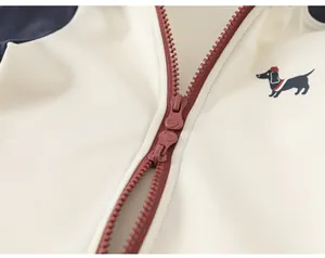 Détail d'un sweat pour bébé fille avec fermeture éclair marron et broderie de chien