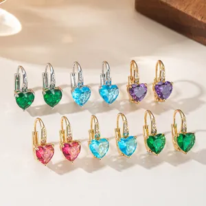 Detail of elegant heart-shaped colorful gemstone earrings in gold and silver finish