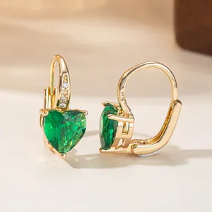 Detailed macro view of elegant heart-shaped green gemstone earrings with gold finish