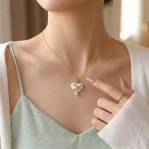 Elegant gold plated necklace featuring white heart pendant with bow zircon and pearl drop