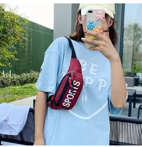 Burgundy sports chest bag with white letter print worn by a model in outdoor setting
