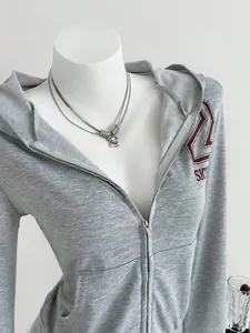 Detailed view of women's grey zip-up hooded sweatshirt with SKY print on a mannequin