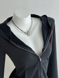Detailed view of women's charcoal gray zip-up hoodie featuring silver layered necklaces