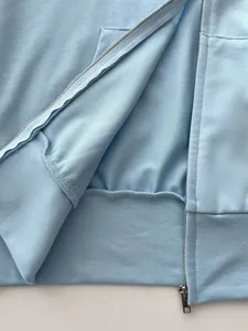 Close-up detail of the metal zipper and interior fabric of a blue zip-up hoodie