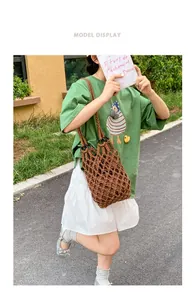 Close-up of a vintage brown woven mesh bag carried by a model in an outdoor park setting.