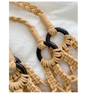 Close-up detail of a handmade knotted beige rope bag featuring dark circular rings