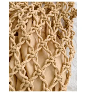 Close-up detail showing the intricate hand-woven macrame knots of the beige mesh handbag