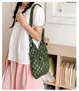 Detail view of the green macramé woven shoulder bag with solid inner liner on model